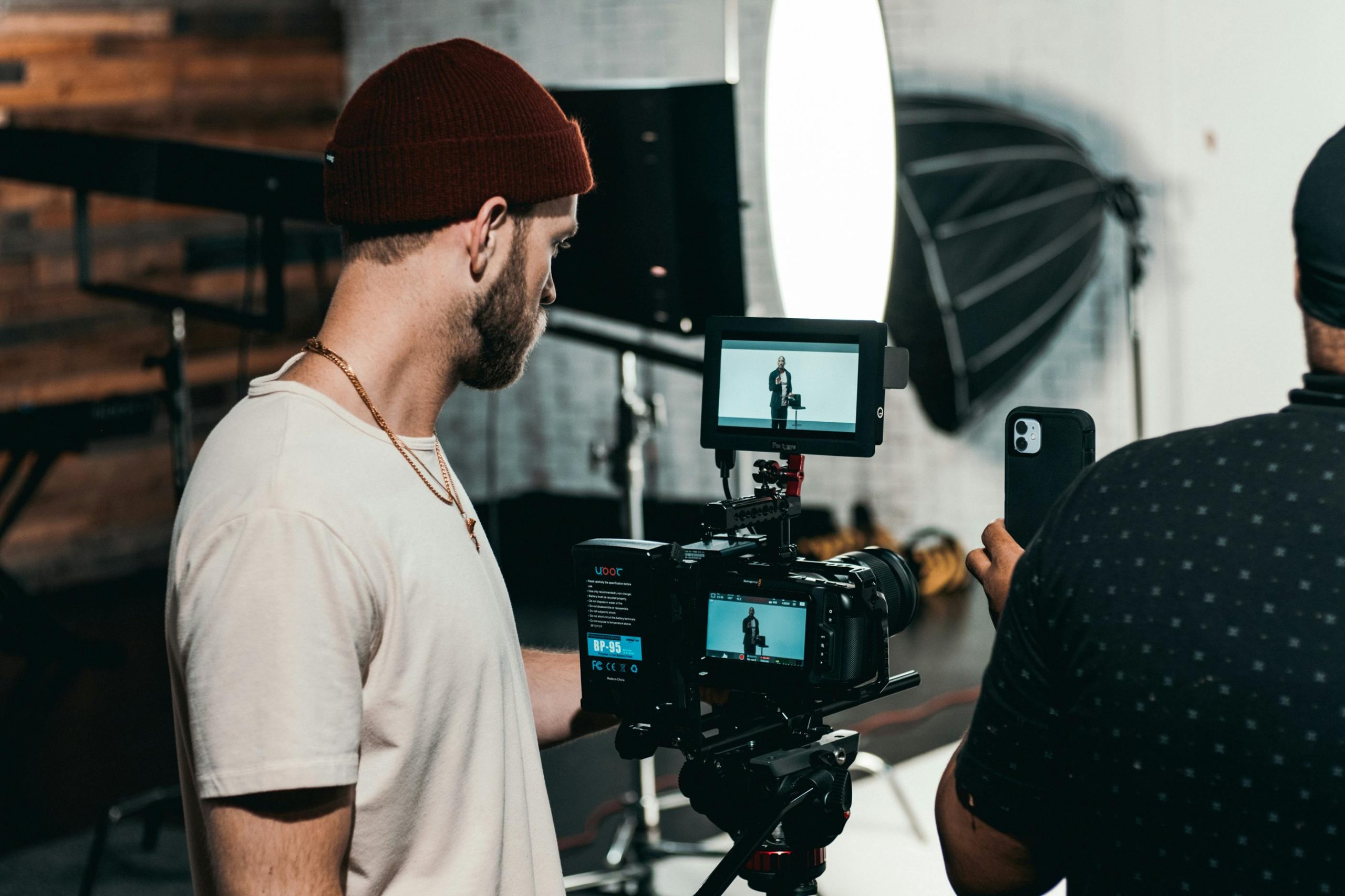 Behind-the-scenes look at a videographer in action in a modern studio workspace.